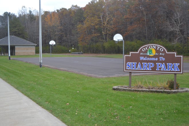 The recently resurfaced  basketball/pickleball court is seen behind the sign for Sharp Park in Oconto. In the background is a newly constructed tennis court. Both projects were done thanks to $26,500 in grants from the Bond Foundation.
