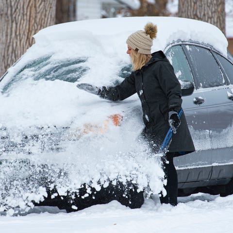 Hanne Murray clears the snow off her car before he