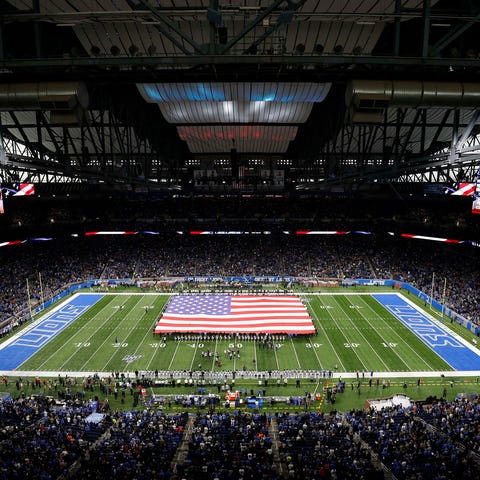 A large American flag displayed on the field durin