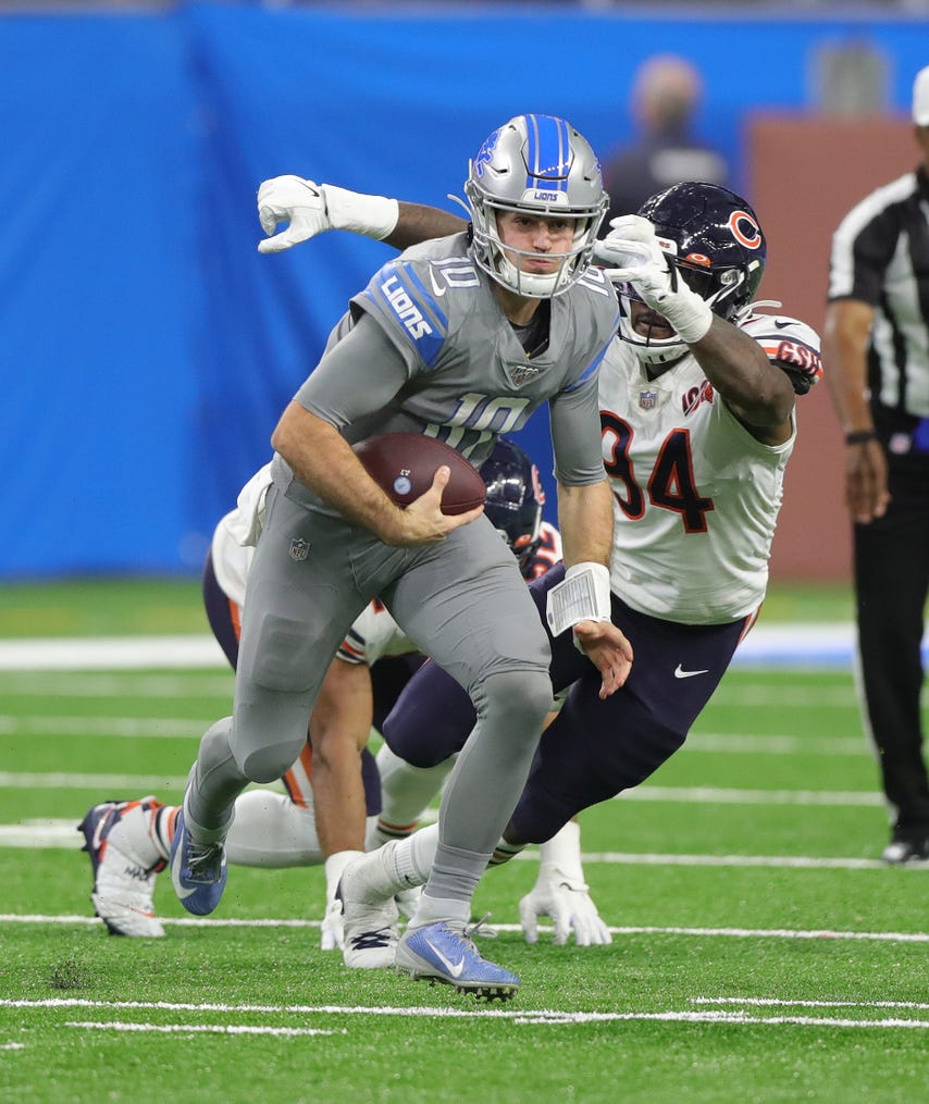 Detroit Lions quarterback David Blough runs by Chicago Bears linebacker Leonard Floyd (94) during the second half Thursday, Nov. 28, 2019 at Ford Field.