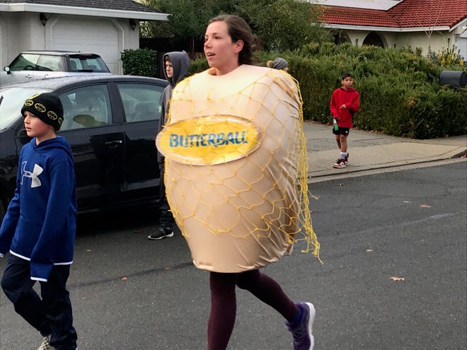 Perhaps this runner is fleeing from the oven? A costumed jogger participates in the 2019 Turkey Trot. For Thanksgiving 2021, the in-person Turkey Chase will be held, while the traditional Turkey Trot will be virtual.