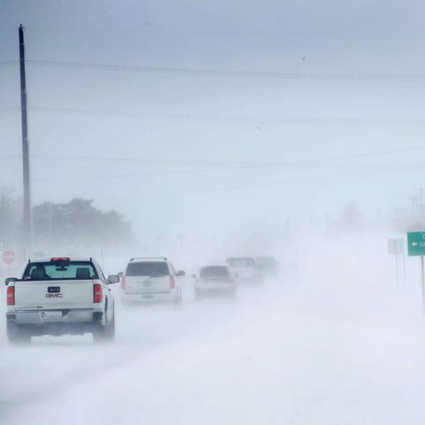 Motorists navigate an ice and snow-covered road on