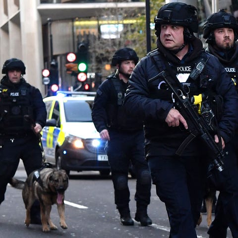 Armed police with dogs patrol along Cannon Street 
