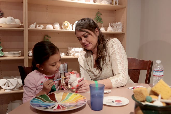 Art is a great way to keep kids entertained during the coronavirus lockdown. Here, Kylie Hayes, 6, and her mom, Kristen, both of Palm Springs, paint a ceramic figure at Gingerbread Lane on November 30, 2019.