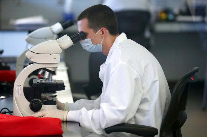 FILE - In this July 6, 2017, file photo, shows a forensic scientist looking through a microscope at the state crime lab, in Taylorsville, Utah. The backlog of untested rape kits is growing even after state lawmakers passed a law in 2017 to address the issue, in part because the legislature didn't provide enough money to hire the necessary technicians for the state crime lab, KUTV reports. (AP Photo/Rick Bowmer, File)