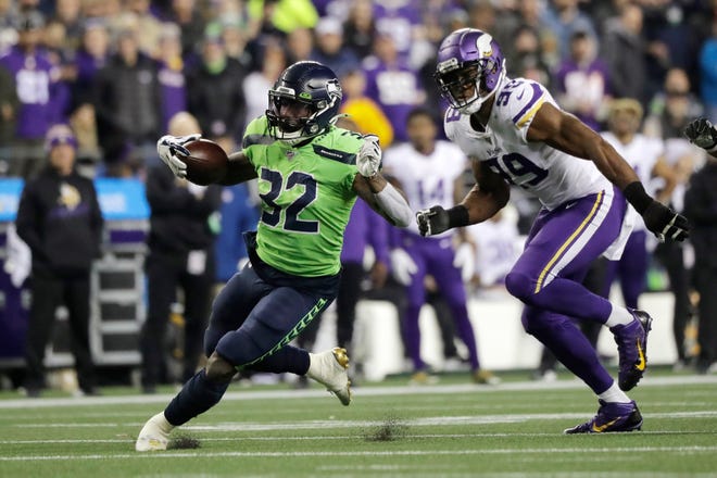 Seattle Seahawks' Chris Carson runs on a 26-yard carry as Minnesota Vikings' Danielle Hunter pursues during the second half of an NFL football game, Monday, Dec. 2, 2019, in Seattle.