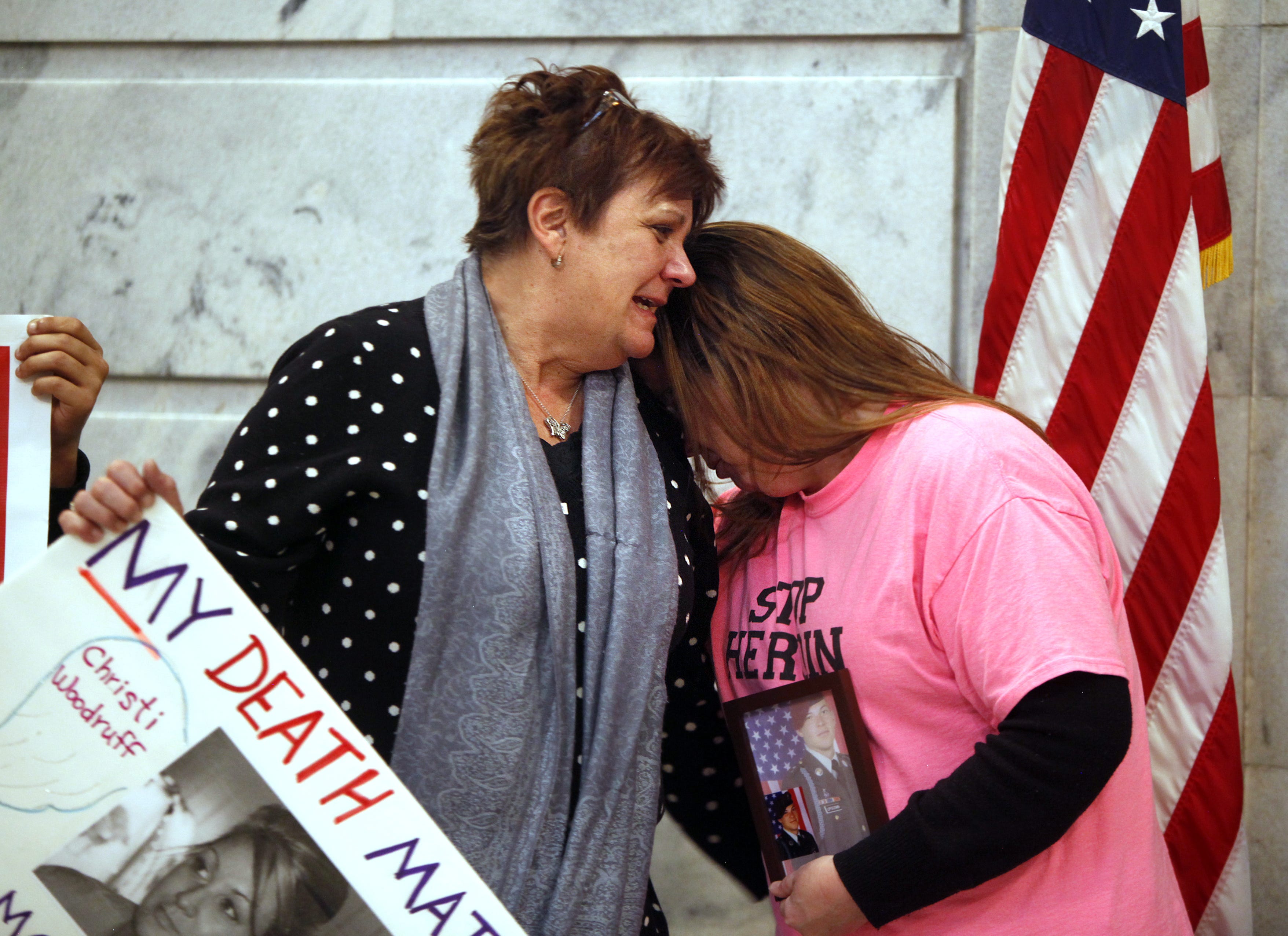 Jenni Woodruff (left), weeps as she clutches a poster with her daughter Christi's photograph. This was in Frankfort, Kentucky, where she was trying to convince legislators to approve needle exchange.