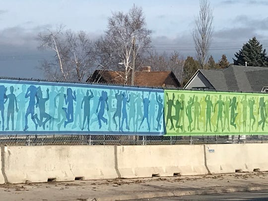 This vinyl covering on the fence surrounding the former Mirro site on Washington Street is the first public art project from the Rahr-West Public Arts Committee. "Art Forward: Hop, Skip, Jump into our Future" uses the silhouettes of local youth to depict children playing.