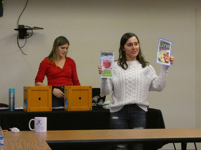 Mindi Klaus, left, a junior at River Valley High School, and Bridget Murphy, right, a senior at Pleasant Local High School, give a presentation about the dangers of vaping at a meeting of Drug Free Marion. Here, Murphy compares the marketing and packaging of a vaping product and a food product.