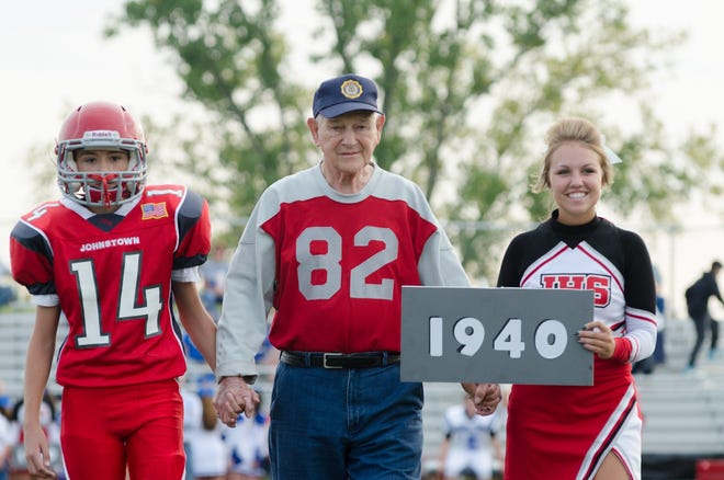 Don Jakeway, center, walks across Johnstown's Frank H. Chambers Stadium field in September of 2015 on Alumni Night with his grandson, freshman Trenton Jakeway, 14, and a Johnstown cheerleader. It was the 75th anniversary of the 1940 team, for which Jakeway played.