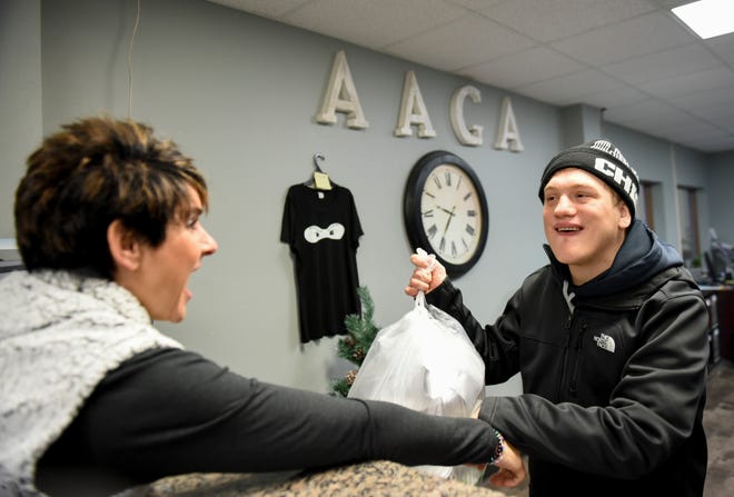 Ben Graff takes out the trash with Kathy Luke on Monday, Dec. 2, 2019 at the All American Gymnastics Academy. Graff has autism and works at the academy. He will continue to work at their new location in the all-abilities cafe.