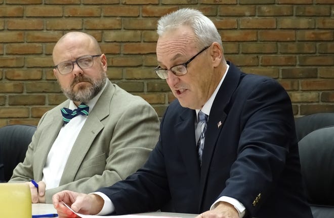 Kevin Myers, left, listens as Dan Wirebaugh speaks against a proposal to extend the residency requirement for the city's service-safety director to a 20-mile radius during Tuesday's Bucyrus City Council meeting.