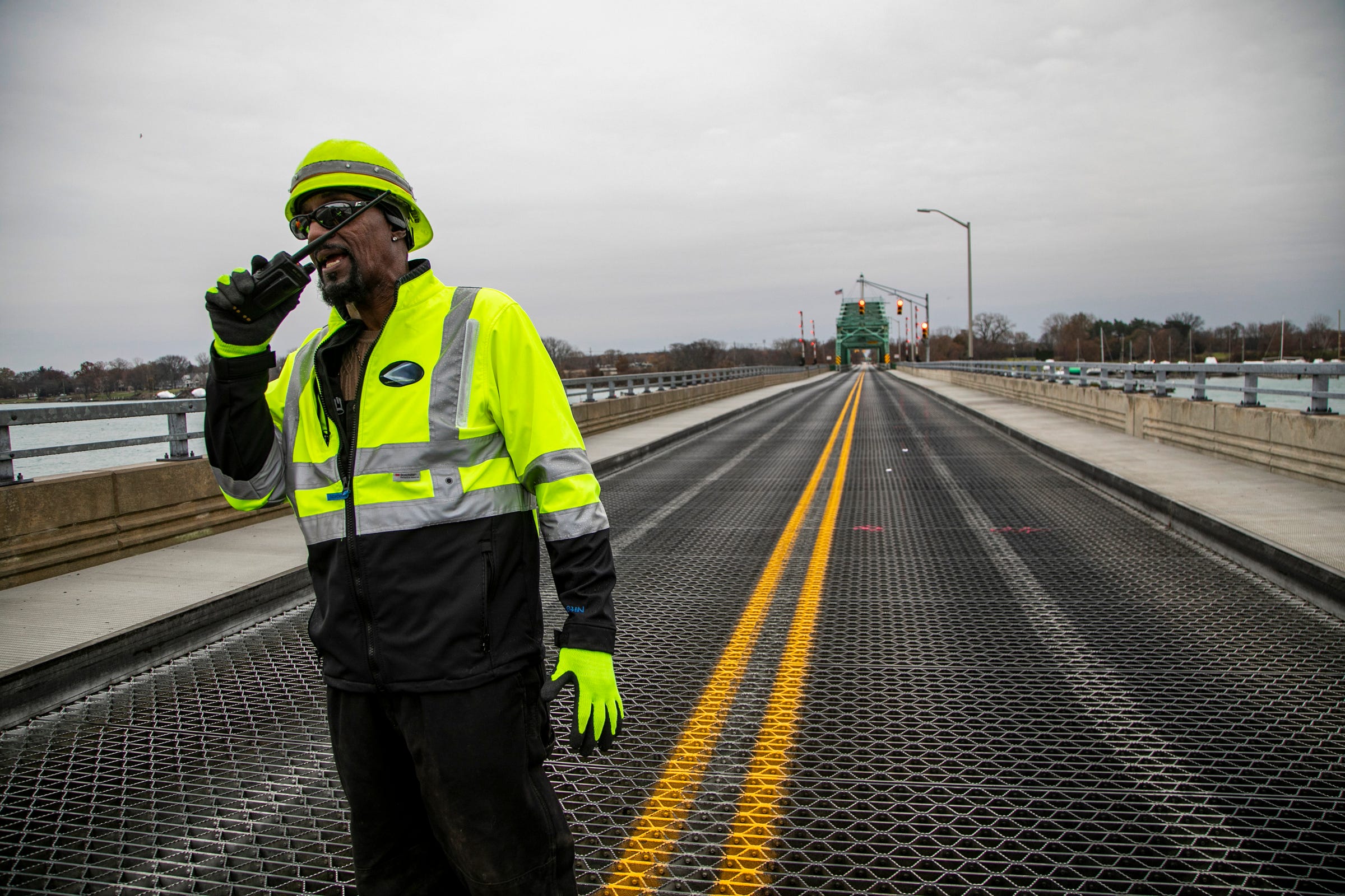 Kevin Gunn, 60, with the Wayne County Department of Public Services radios the official opening of the Grosse Ile Parkway free bridge to the public Thursday, Nov. 21, 2019 after the bridge was closed for critical repairs.