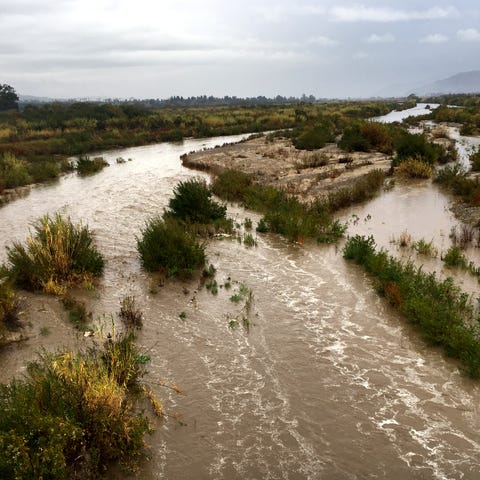 Water flows through the Santa Clara River beneath 