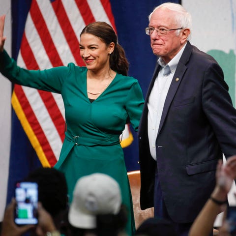 Rep. Alexandria Ocasio-Cortez, D-N.Y stands alongs