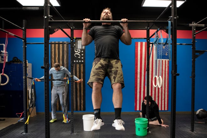 Battle Creek CrossFit owner Clay Moore does pullups on Friday, Dec. 6, 2019 in Battle Creek, Mich. Battle Creek CrossFit recently moved locations from Columbia Ave. to downtown on Michigan Ave.