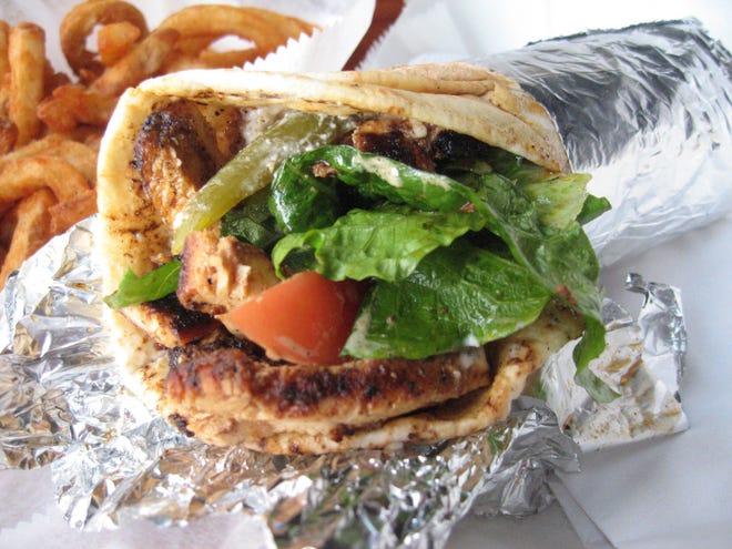 The chicken shawarma sandwich at Detroit's Bucharest Grill is made with hot-off-the-grill strips of marinated chicken, lots of pungent garlic sauce, dill pickle spears, and fresh romaine and tomato.