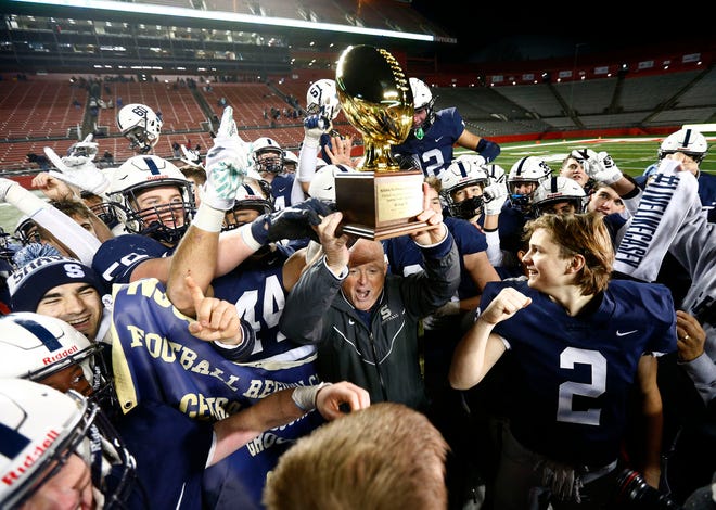 Shawnee High School football coach Tim Gushue hoists the trophy after winning the NJSIAA Group 4 Championship over Hammonton at SHI Stadium in Piscataway Saturday, December 7, 2019.