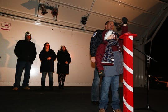 Ryan Terebetsky provides the magic touch to light the Christmas tree.