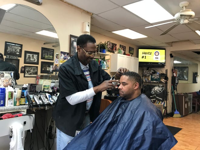 Todd "TI" Israel works in his Haddon Avenue barbershop in December. His business has had to close in the midst of the COVID-19 pandemic and he worries about his future.