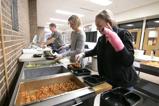 From left, Meals on Wheels volunteers Gary LaRoy, Lorrie Cabush and Sue LaRoy serve and package a goulash lunch for seniors in the Hartland Educational Support Service Center Monday, Dec. 9, 2019.
