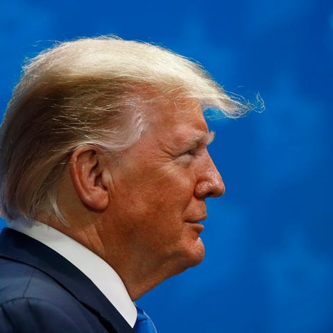 President Donald Trump listens as Miriam Adelson, 