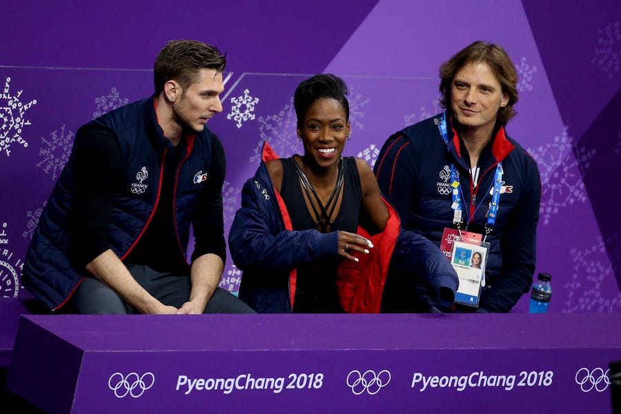 Morgan Cipres, left, is shown with John Zimmeran, far right -- and Cipres' partner, Vanessa James -- after completing the free program at the Olympics in 2018.