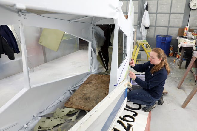 Jenny Haver tapes off a plane for painting at MMS Aviation in Coshocton. Haver is an aircraft maintenance supervisor for the company.