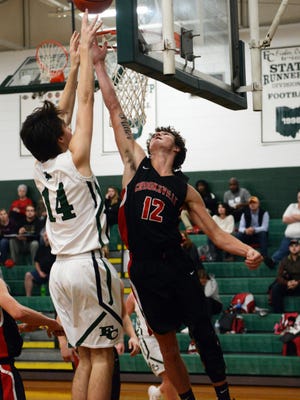 Crooksville's Caden Miller tries to block a shot against Fisher Catholic's Josh Burke, left, during their game on Monday in Lancaster. Fisher won, 61-53, to stay unbeaten.