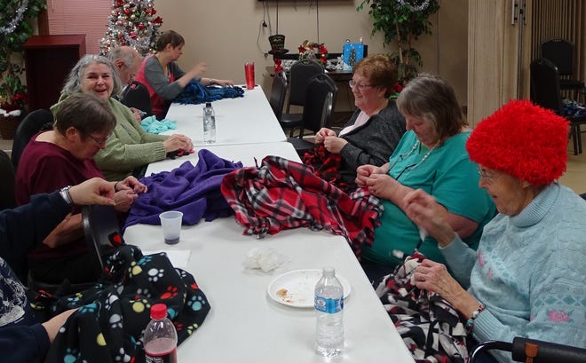Volunteers knot the fringes on fleece blankets on Tuesday at the Crawford County Council on Aging. From left are Mary Stuckert, Gerry Sams, John Sams, Amy Ward, Bev Whaley, Gloria Pelfry and Marilyn Smith.