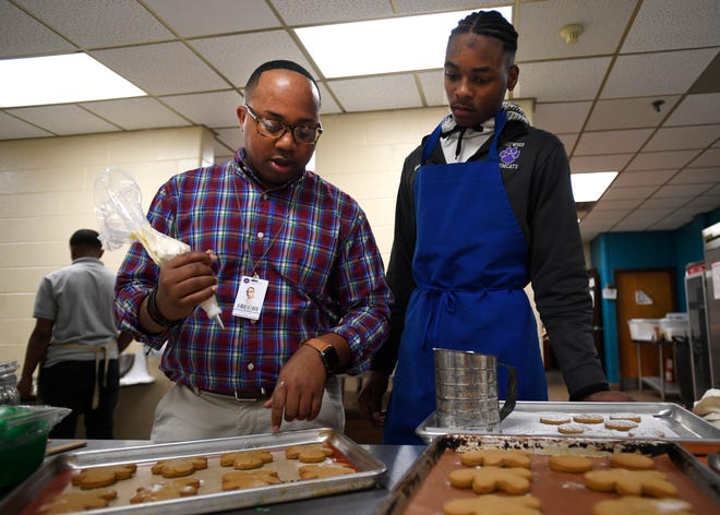 Tim Hayes shows Shocorius Sweet how to pipe icing on gingerbread cookies in his classroom at Haywood High School in Brownsville, Tenn on Tuesday, Dec. 10, 2019. Hayes teaches his students culinary arts and was also a contestant on the Netflix Series Sugar Rush.
