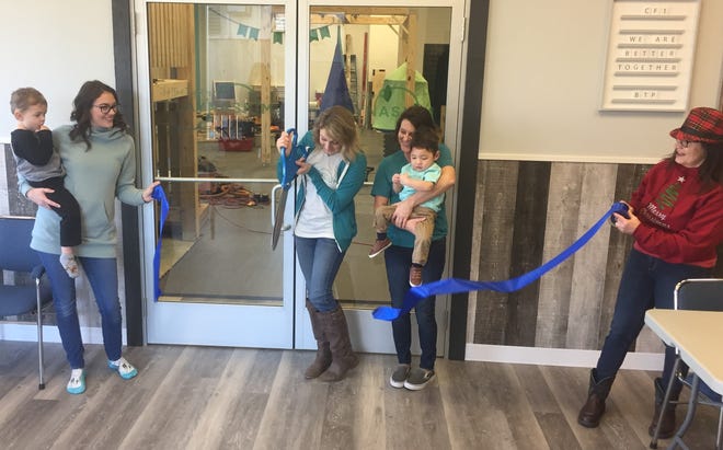 Amber Pierson officially cuts the ribbon, opening "Better Together Playnasium" at at 5089 York Road, while her mother, Mary Poole, and her son, Kai, inspiration for the enterprise, look on Dec. 11.