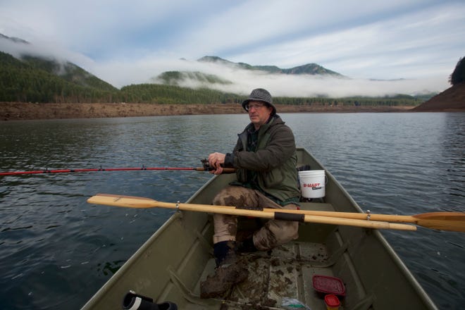 Henry Hughes fishes from a small Jon boat in the historically low water of Detroit Lake during the winter of 2019.