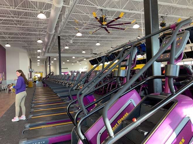 Amber Crider, club manager of Planet Fitness in Waukesha, works out operational details with her new staff during the gym's opening week in early December. The 20,000-square-foot fitness center joins an unusually long list of gyms in the city.