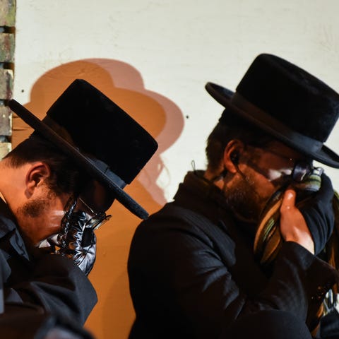 Two men wipe their eyes during the funeral of Leah