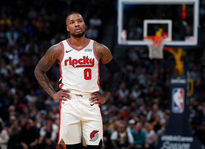 Portland Trail Blazers guard Damian Lillard looks on during a break in play in the first half of an NBA basketball game against the Denver Nuggets, Thursday, Dec. 12, 2019, in Denver.