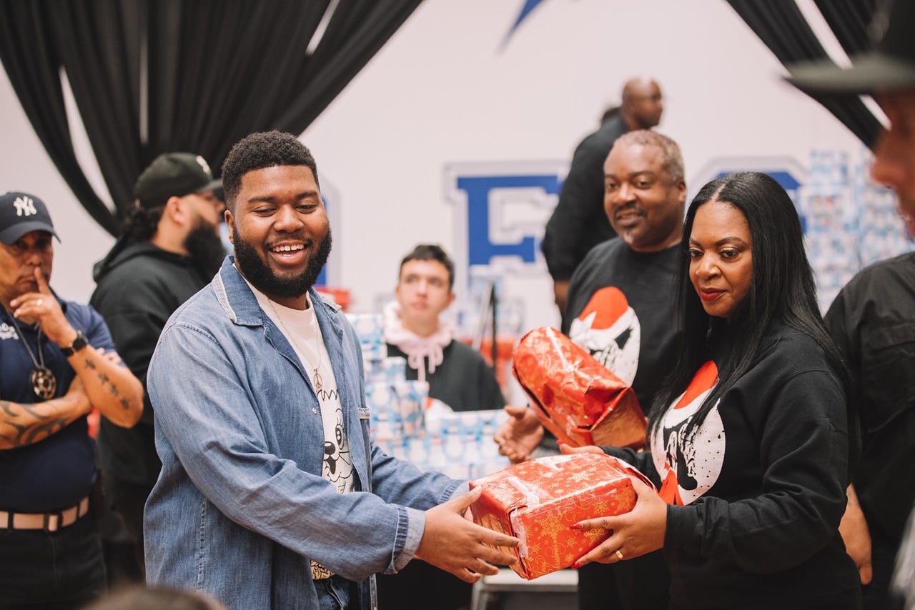 Khalid and his mother, Linda Wolfe, hand out Christmas gifts at Del Valle Middle School in 2019. The chart-topping singer and songwriter came to El Paso his senior year of high school and now calls the city home.