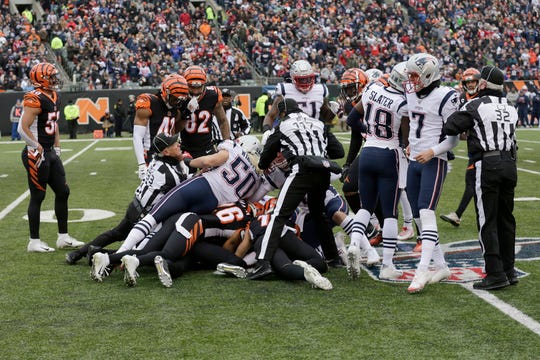 Players dive on a loose ball as Cincinnati Bengals wide receiver Alex Erickson (12) fumbles a punt in the second quarter of the NFL Week 15 game between the Cincinnati Bengals and the New England Patriots at Paul Brown Stadium in downtown Cincinnati on Sunday, Dec. 15, 2019. The Patriots led 13-10 at the half.