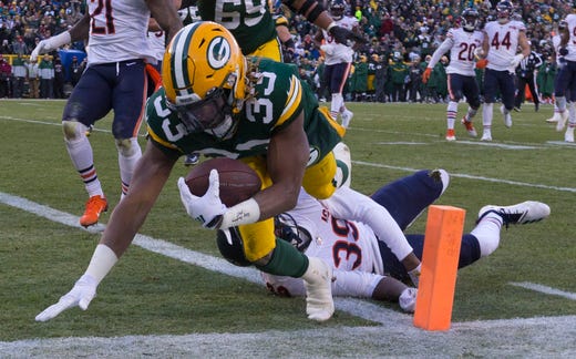 Green Bay Packers running back Aaron Jones (33) scores touchdown on a 21-yard run despite the efforts of Chicago Bears free safety Eddie Jackson (39) during the third quarter of their game Sunday, December 15, 2019 at Lambeau Field in Green Bay, Wis. The Green Bay Packers beat the Chicago Bears 21-13.