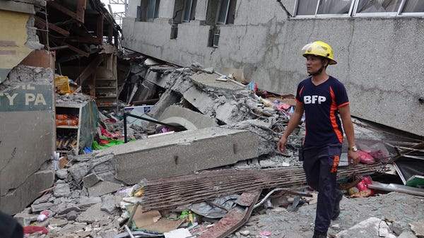 A fireman inspects a damaged market in the quake-h