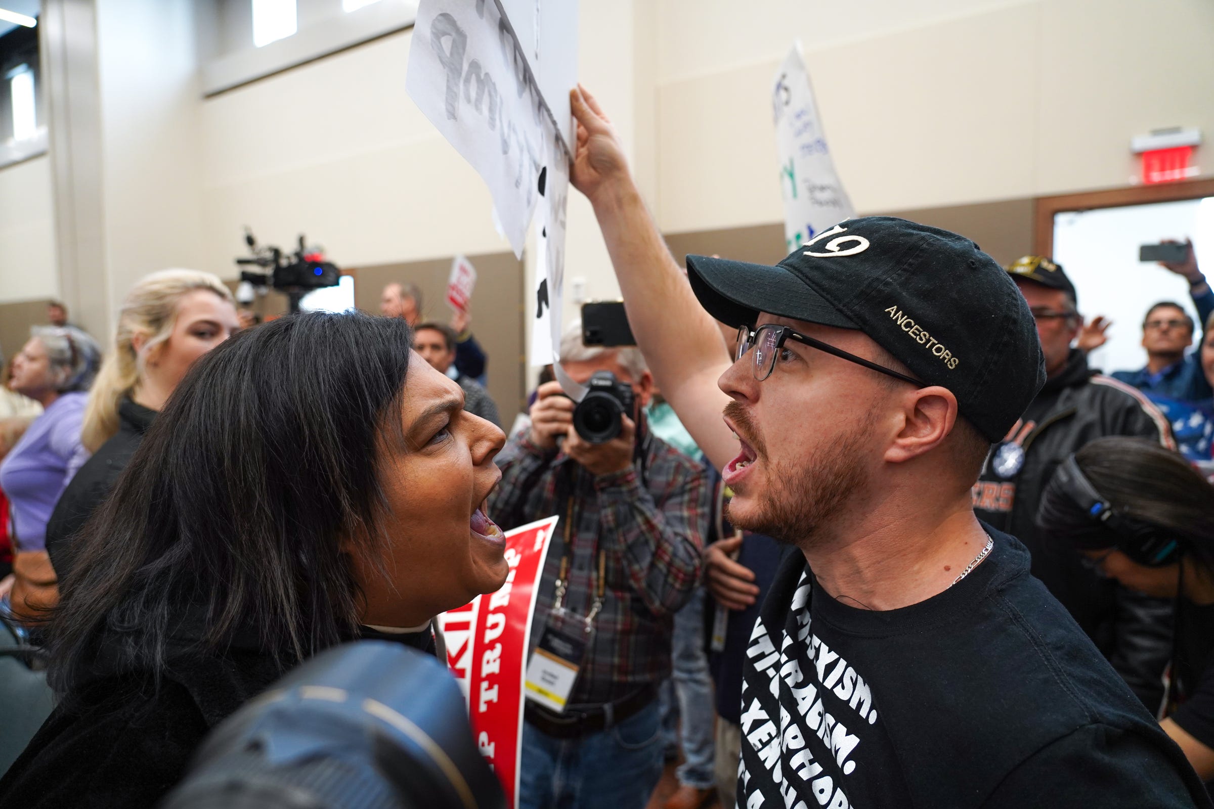 Trump supporter Deborah Day of Howell gets in the face Louie Fanelli of Auburn Hills as he holds a sign for ending white supremacy while standing amongst Trump supporters in the back of the room as U.S. Rep. Elissa Slotkin holds a constituent community conversation on Monday, December 16, 2019 at the Oakland Center at Oakland University in Rochester.