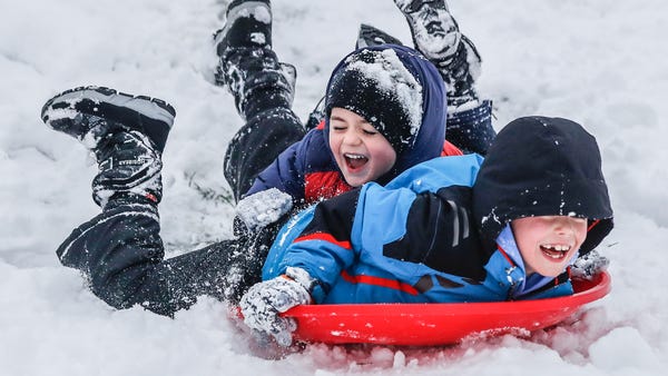 Baxter, right, and Lewie Flett, left, sled down a 