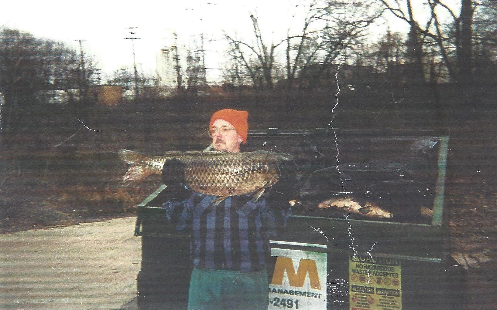 A man carries dead fish from the White River to a dumpster after the Guide spill in December of 1999. The Guide Corp. in Anderson dumped toxic chemicals into the White River, ultimately killing more than 4 million fish through Downtown Indianapolis.