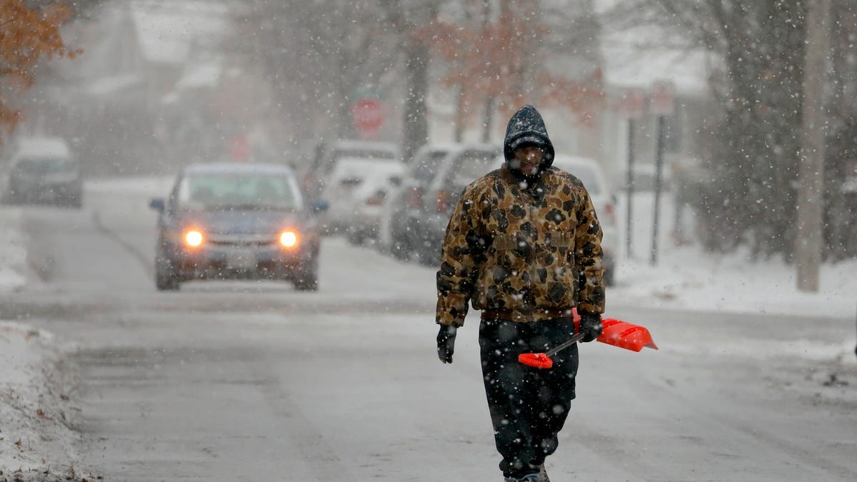 Bill Parham walks down an icy street in Maplewood, Mo., looking to clear snow off people's driveways and sidewalks on Monday, Dec. 16, 2019. The wintry weather was part of a storm system that hit parts of the Midwest and was expected to extend into the Northeast through Tuesday, the National Weather Service said.