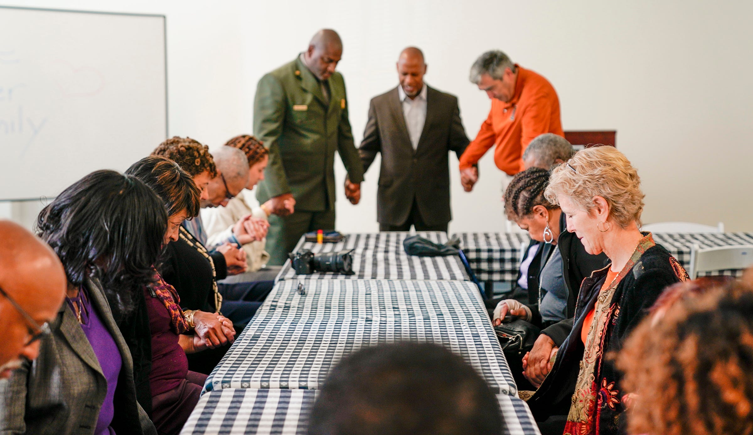 Members of the Tucker family pause to pray together over lunch in Hampton, Virginia.