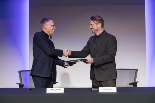 PSA CEO Carlos Tavares, left, and Fiat Chrysler CEO Mike Manley shake hands in December on an agreement to combine their companies. The Stellantis deal closed Saturday.