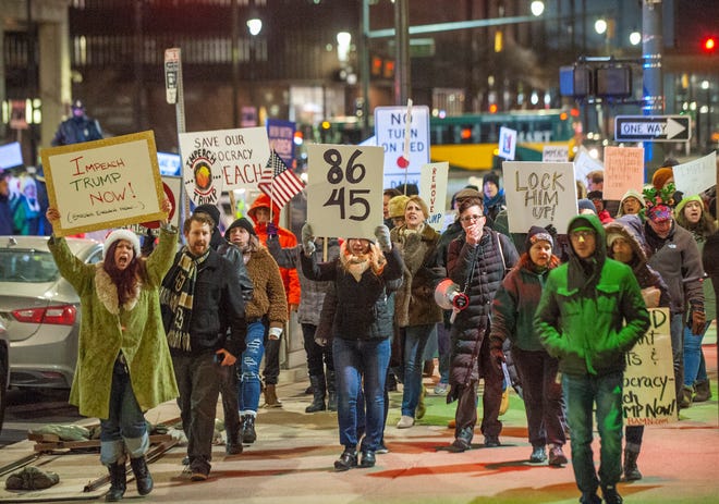 More than one hundred a pro-impeachment activists march along Fort Street in downtown Detroit on Tuesday night, on the eve of the U.S. House of Representatives' formal vote on impeachment against President Donald Trump.