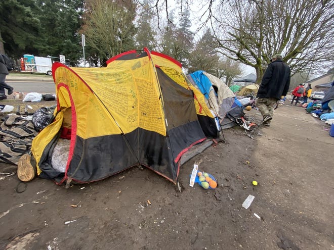 Members of a homeless camp in downtown Salem, Ore., begin to dismantle their tents as city officials enforce a ban on camping on city property.