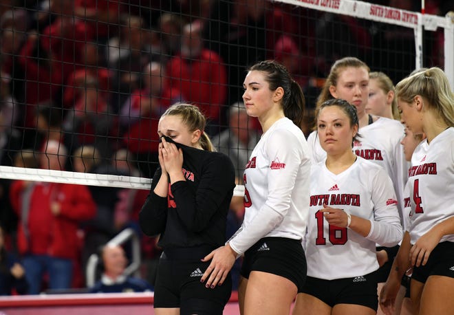 Anne Rasmussen of USD wipes her eyes with her shirt as she lines up to shake hands with Georgia Tech following USD's loss in the National Invitational Volleyball Championship on Tuesday, Dec. 17, at the Sanford Coyote Sports Center in Vermillion.