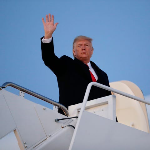 President Donald Trump waves while boarding Air Fo